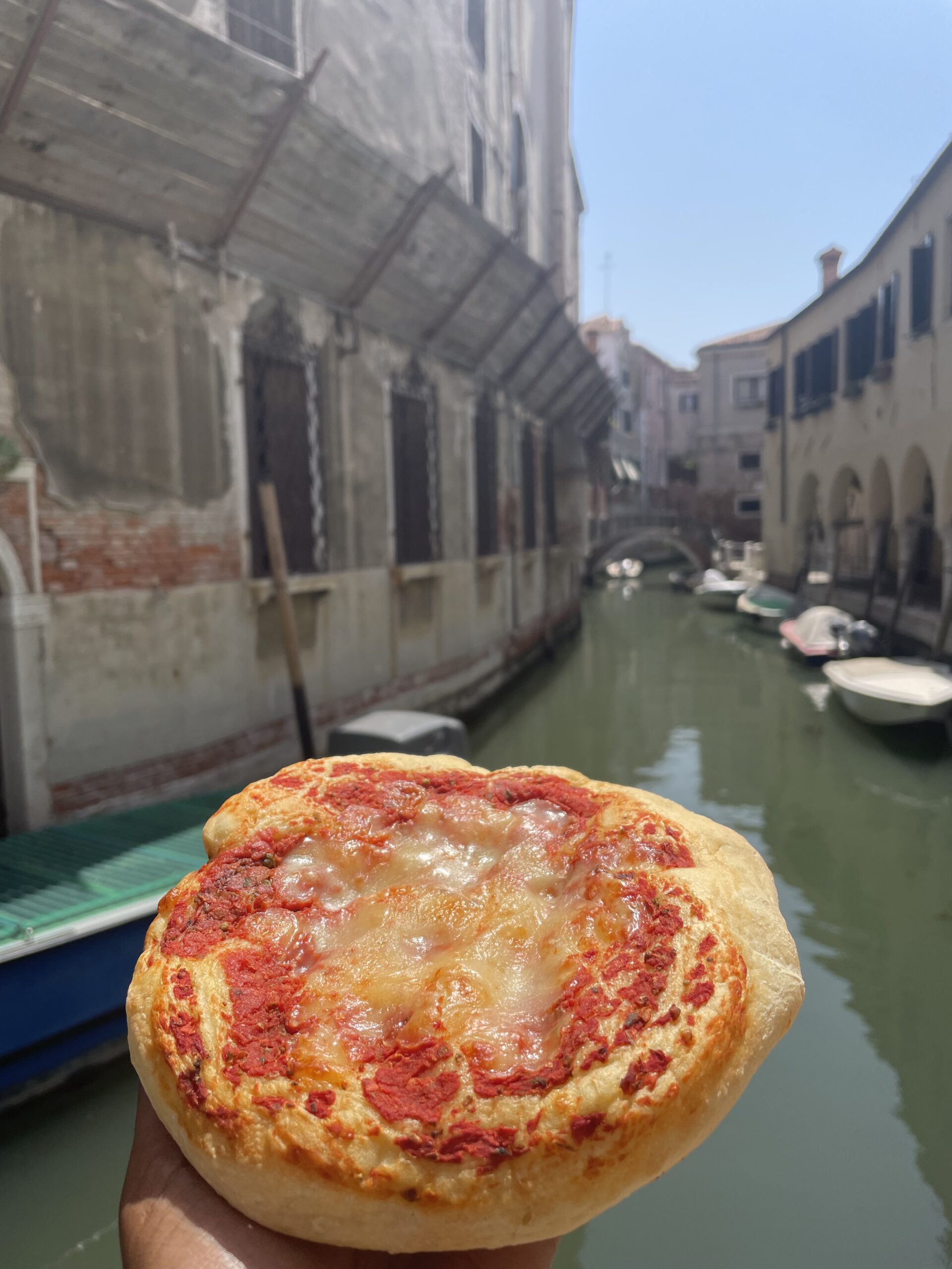 Solo female traveler tasting pizza during a solo travel adventure in Venice