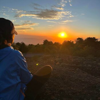 Solo female traveler enjoying a sunset view in Sicily, Italy with scenic landscape
