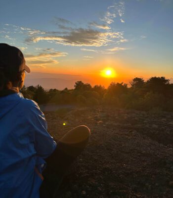 Solo female traveler enjoying a sunset view in Sicily, Italy with scenic landscape