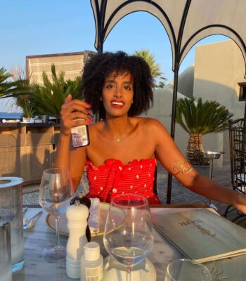 Solo female traveler enjoying dinner in Rhodes, Greece, practicing self-care tips while traveling alone