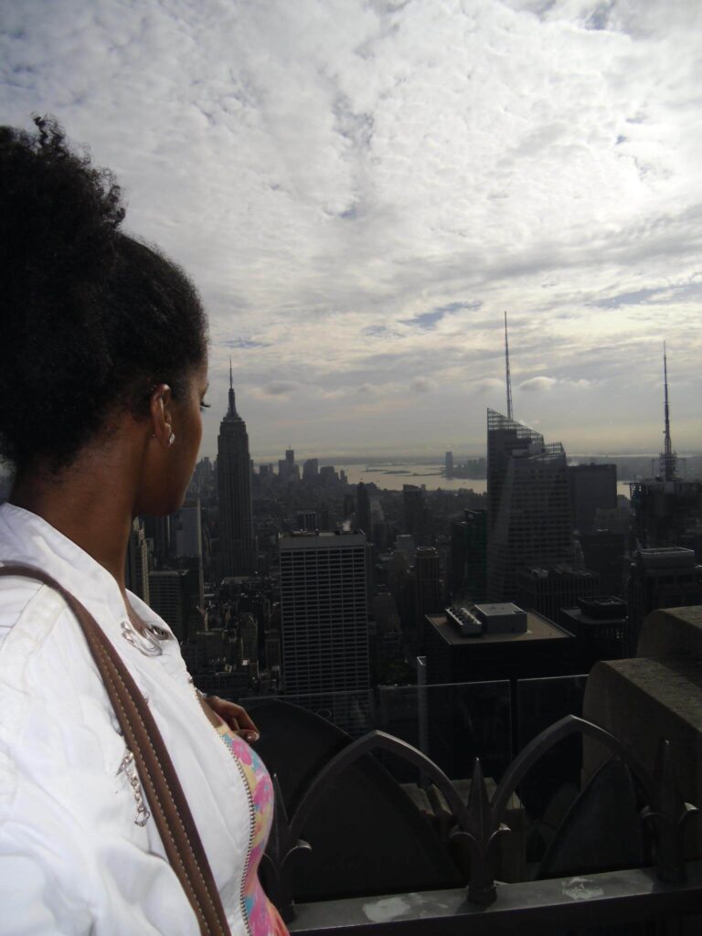 Solo female traveler enjoying New York City skyline, standing with view of skyscrapers and cityscape, solo travel inspiration