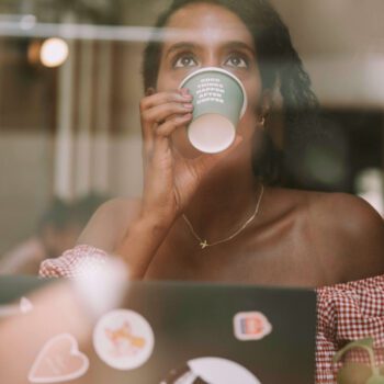 Solo female traveler drinking coffee and working remotely in Barcelona, Spain