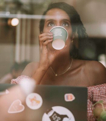 Solo female traveler drinking coffee and working remotely in Barcelona, Spain