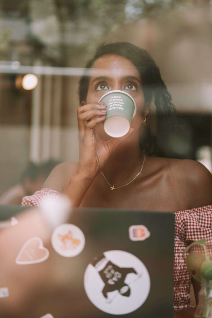 Solo female traveler drinking coffee and working remotely in Barcelona, Spain