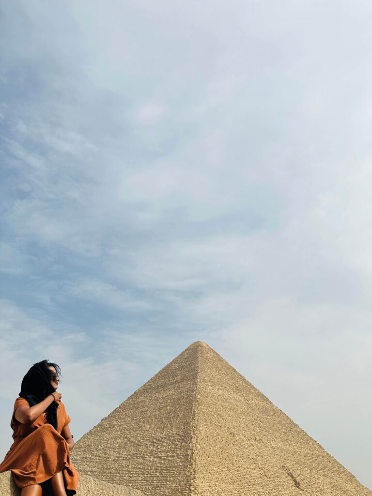Solo female traveler enjoying the view of the Pyramids of Giza in Cairo, Egypt