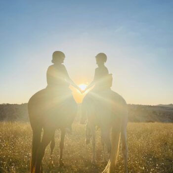 Two female travelers riding horses at sunset in Turkey