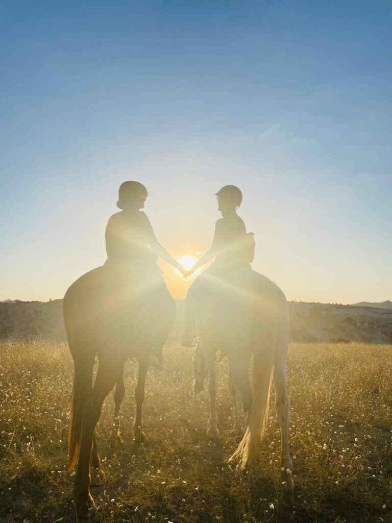 Two female travelers riding horses at sunset in Turkey
