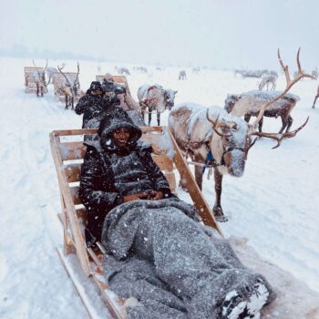 Solo female traveler in Tromsø enjoying a reindeer sledding experience in the Arctic