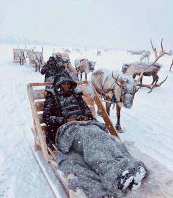 Solo female traveler in Tromsø enjoying a reindeer sledding experience in the Arctic