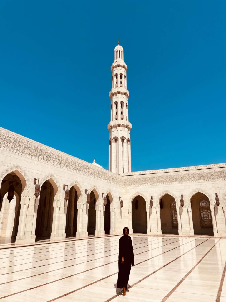 Solo female traveler visiting a mosque in Oman, embracing cultural experiences