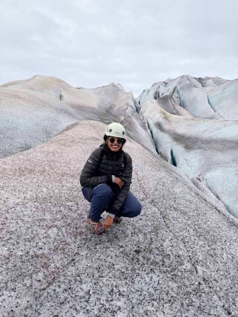 Adventurous woman exploring remote Greenland landscapes alone, with snow, ice, and rugged natural scenery.