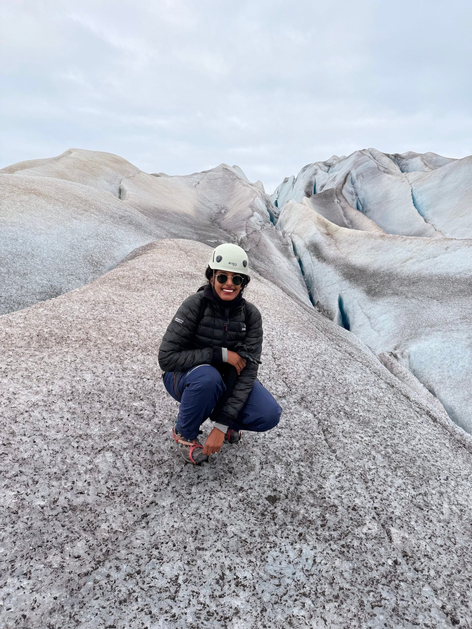 Adventurous woman exploring remote Greenland landscapes alone, with snow, ice, and rugged natural scenery.