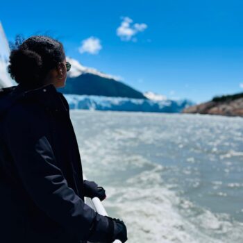 Solo female traveler in Argentina on a boat approaching a glacier, exploring the breathtaking Patagonian scenery.