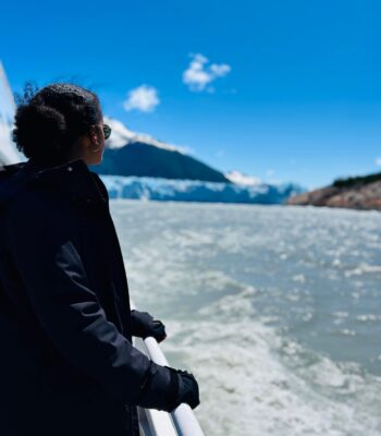 Solo female traveler in Argentina on a boat approaching a glacier, exploring the breathtaking Patagonian scenery.
