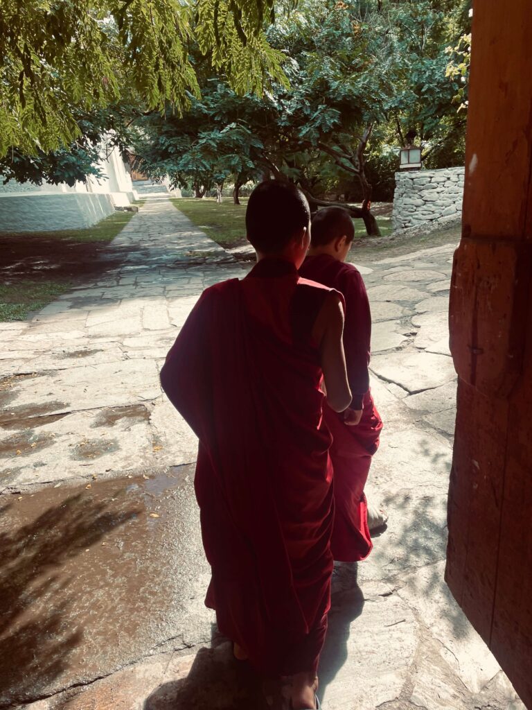 Solo female traveler observing monks at a Bhutanese monaster