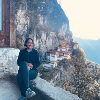 Solo woman hiking to Tiger’s Nest Monastery in Bhutan surrounded by lush mountains