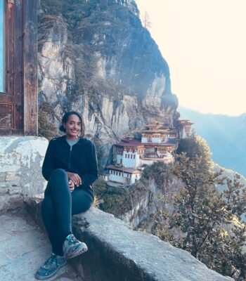 Solo woman hiking to Tiger’s Nest Monastery in Bhutan surrounded by lush mountains