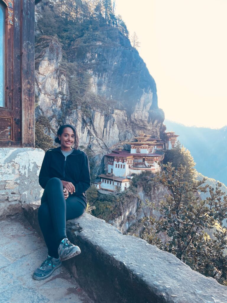 Solo woman hiking to Tiger’s Nest Monastery in Bhutan surrounded by lush mountains