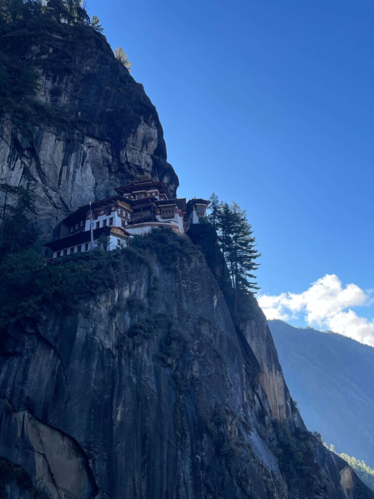 Solo female traveler hiking in Bhutan with Tiger’s Nest Monastery in the background