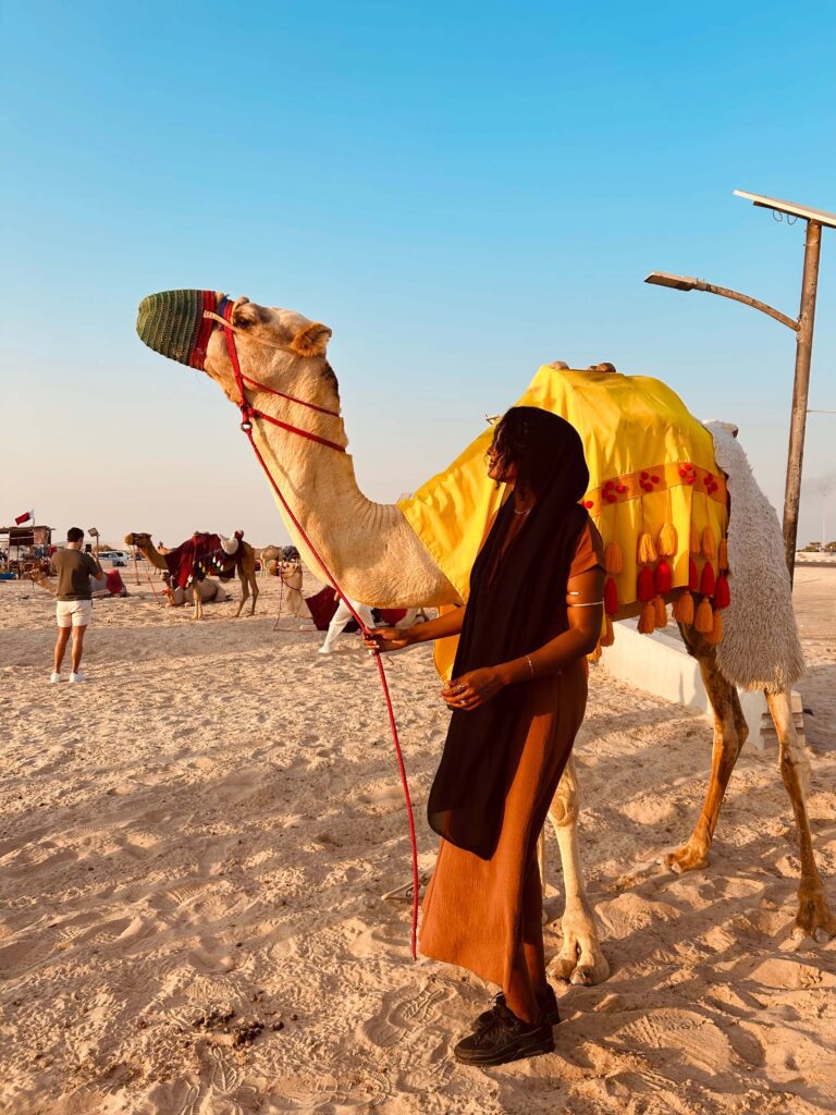 Solo female traveler riding a camel in the desert of Oman
