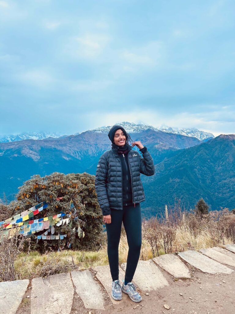 Solo female traveler hiking in the Himalayas, Nepal, enjoying mountain adventure alone