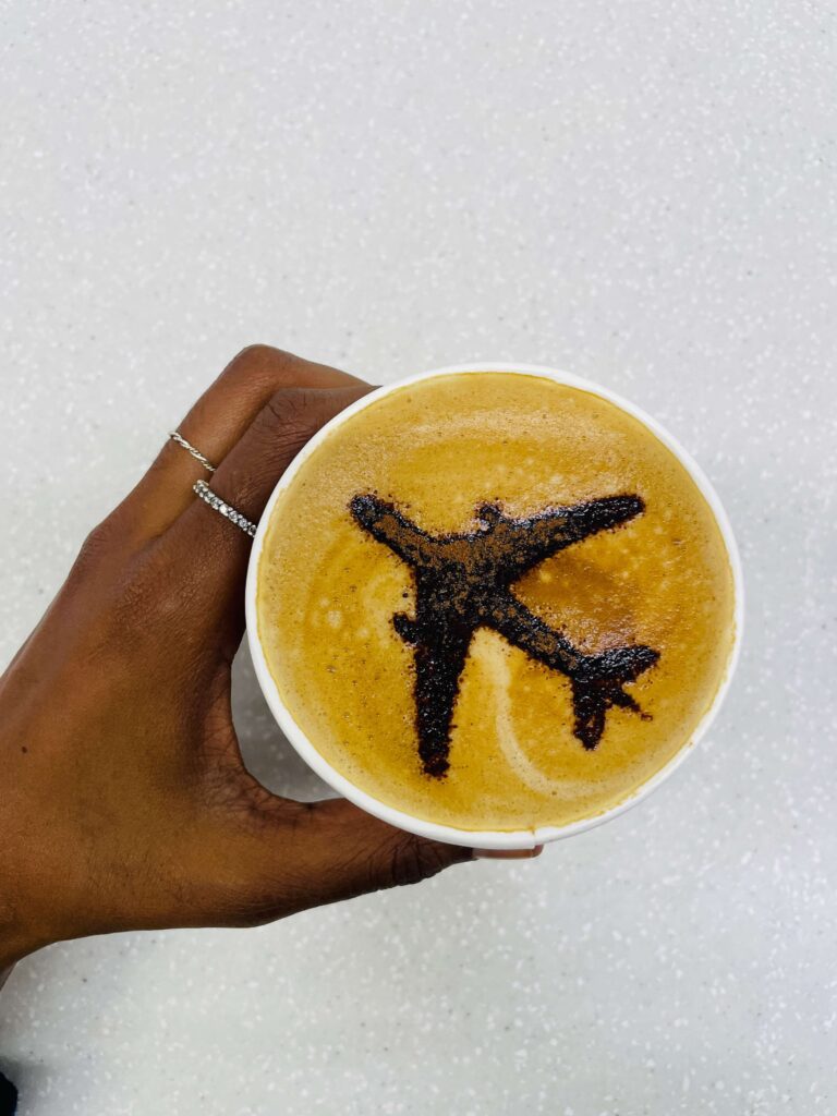 Latte coffee with airplane latte art, perfect coffee for solo female travelers, cafe aesthetic