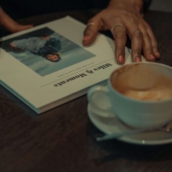 Solo female traveler planning a trip with a travel book in a coffee shop
