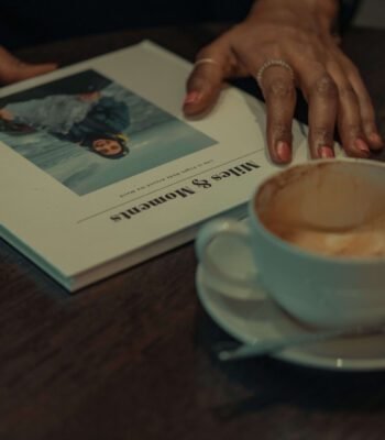 Solo female traveler planning a trip with a travel book in a coffee shop