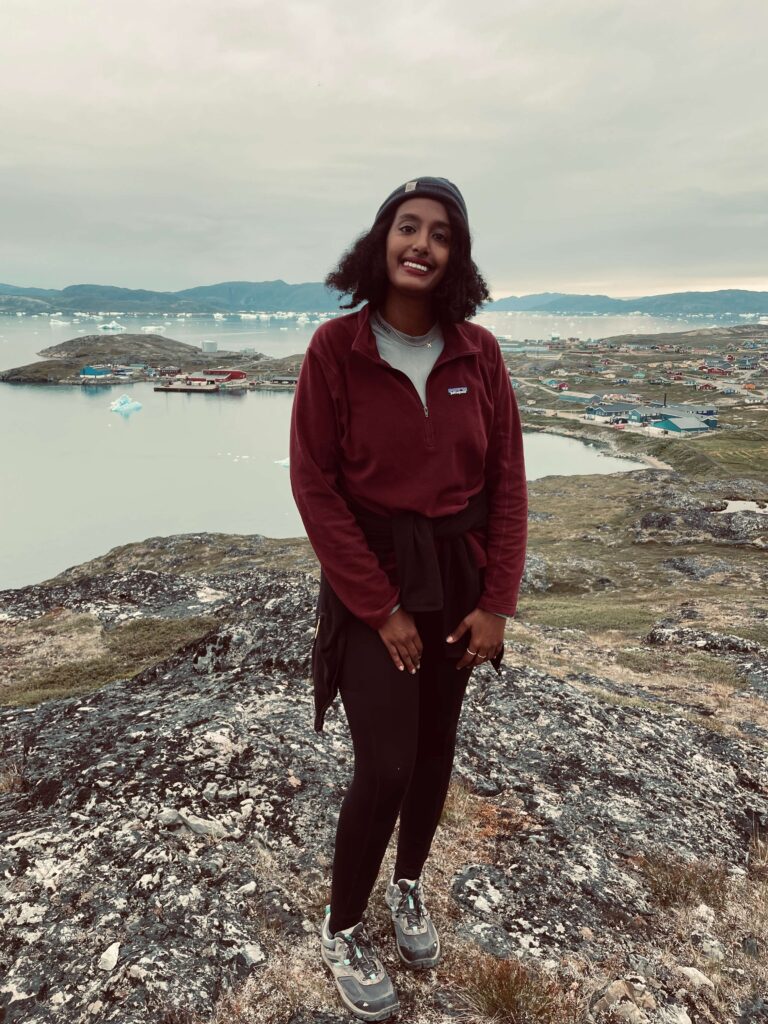Solo female traveler hiking in Greenland mountains surrounded by Arctic wilderness