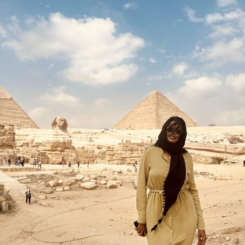 Solo female traveler exploring the Cairo pyramids during a travel adventure in Egypt
