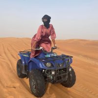 Woman traveling alone in Dubai desert dunes