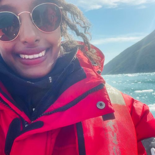 Solo female traveler in Greenland with iceberg view