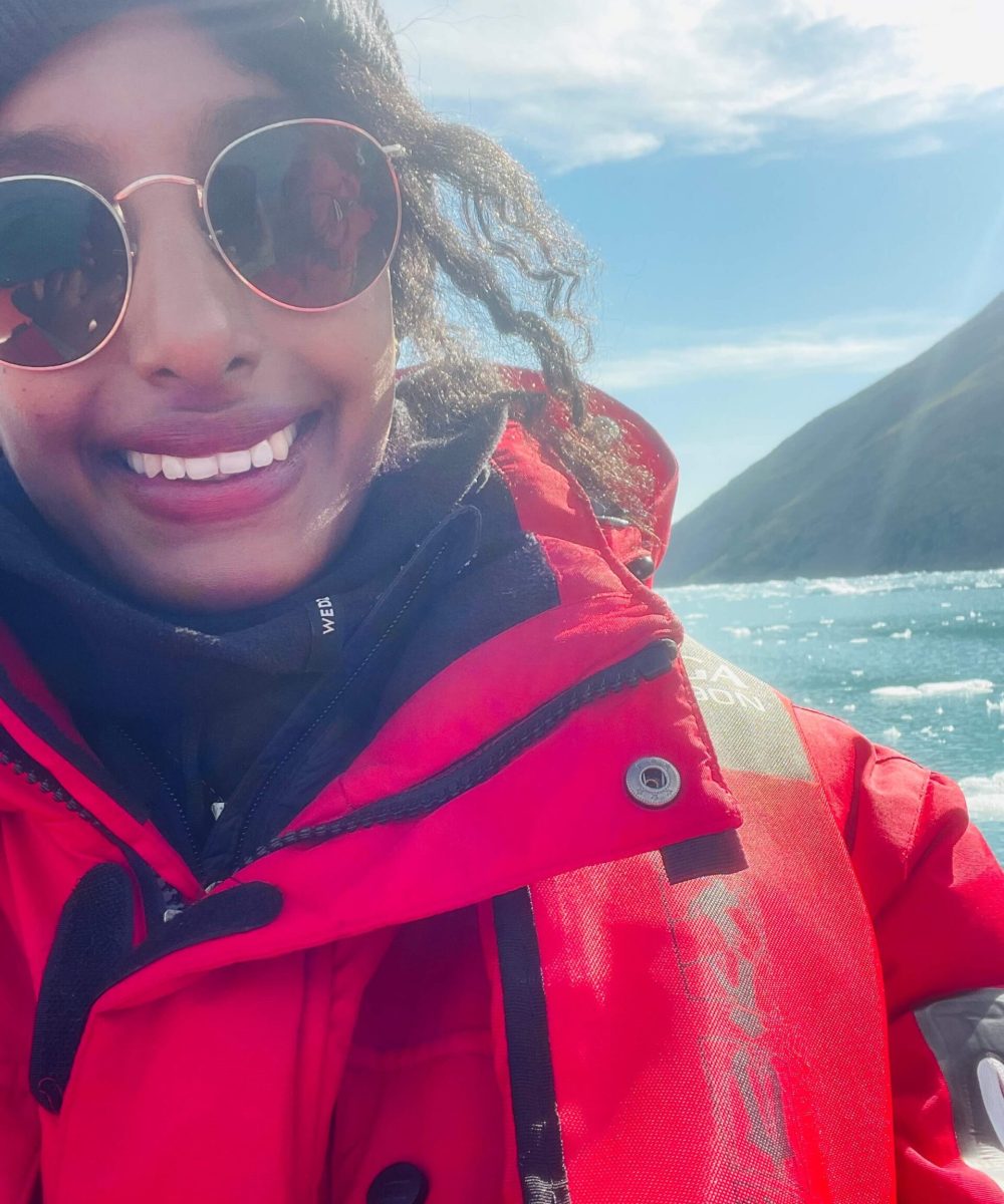Solo female traveler in Greenland with iceberg view