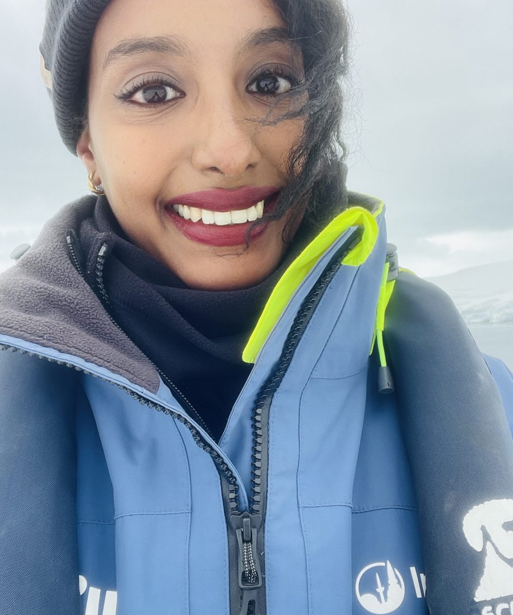 Solo female traveler on a Zodiac boat tour through Antarctica's icy landscapes
