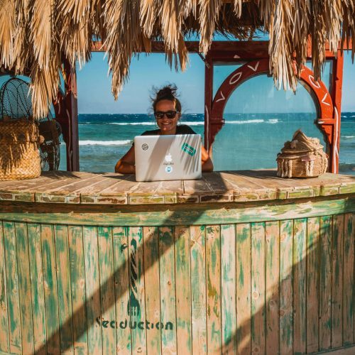 Solo remote worker using a laptop on a tropical beach