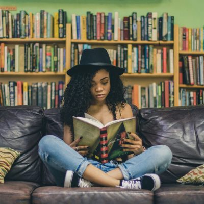 Solo female traveler reading travel books for inspiration and trip planning
