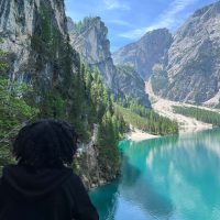 Female solo traveler taking photos of Dolomites peaks